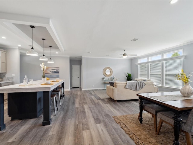 living room featuring ceiling fan, light hardwood / wood-style flooring, and crown molding