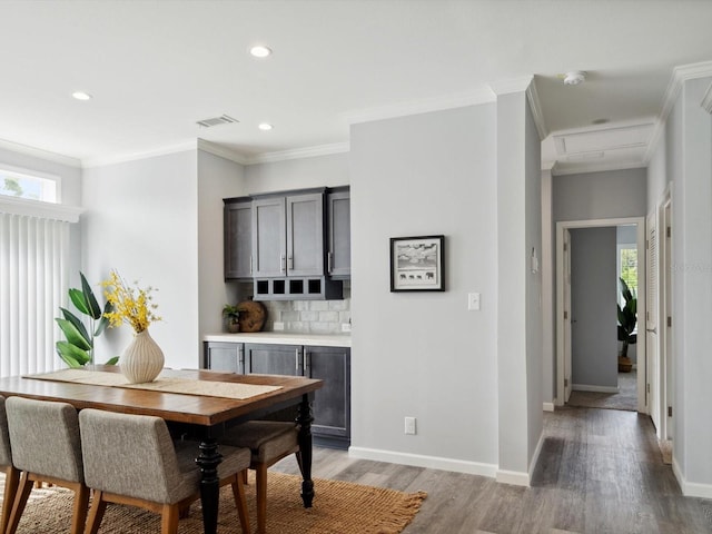 dining room featuring a wealth of natural light, hardwood / wood-style floors, and crown molding