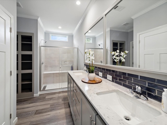 bathroom with vanity, a shower with door, crown molding, decorative backsplash, and wood-type flooring