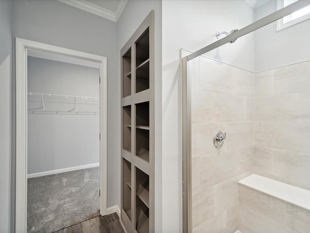 bathroom featuring hardwood / wood-style floors, crown molding, and walk in shower