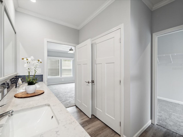 bathroom featuring crown molding, vanity, wood-type flooring, and ceiling fan