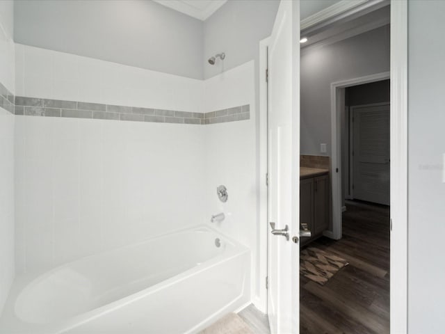 bathroom with ornamental molding, shower / bath combination, and hardwood / wood-style flooring