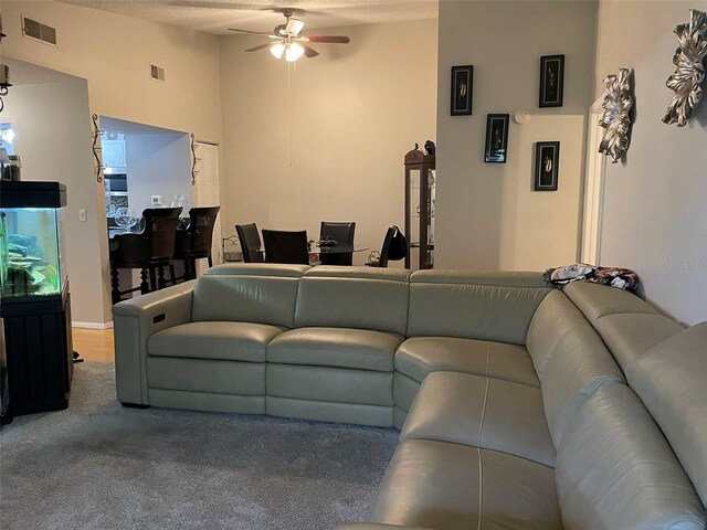 carpeted living room featuring a textured ceiling, a high ceiling, and ceiling fan