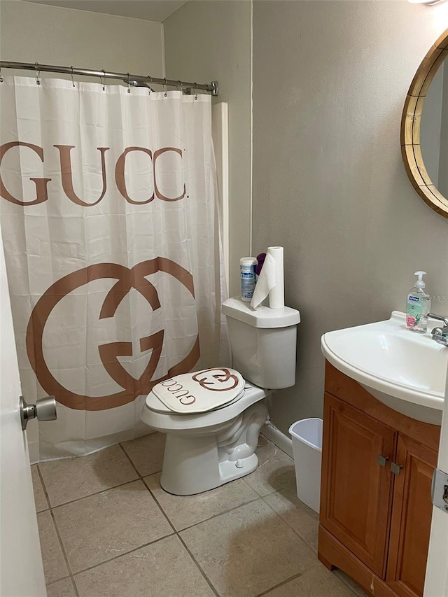 bathroom featuring tile patterned flooring, toilet, and vanity