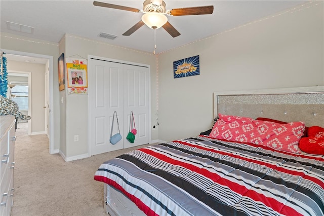 bedroom featuring light colored carpet, a closet, and ceiling fan