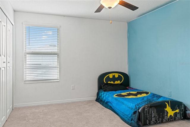 bedroom featuring ceiling fan, a closet, and light colored carpet