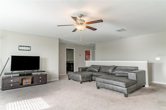 carpeted living room featuring ceiling fan and a textured ceiling