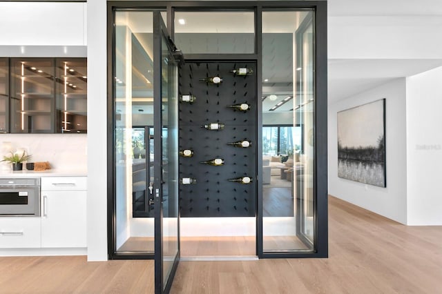 wine area with light hardwood / wood-style flooring