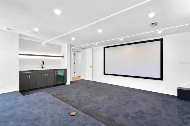 home theater room featuring dark carpet, wet bar, and wine cooler