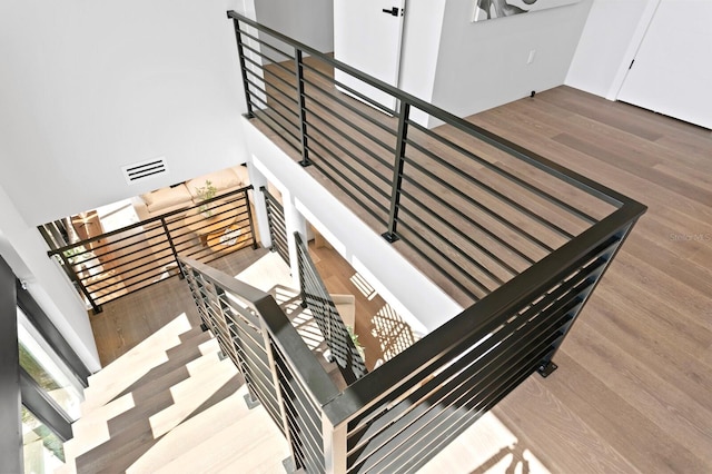 stairway featuring wood-type flooring and a high ceiling