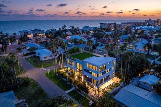 aerial view at dusk featuring a water view