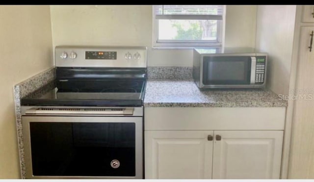 kitchen with white cabinets and appliances with stainless steel finishes