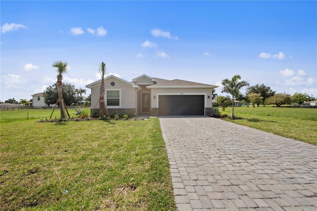 ranch-style house featuring a garage and a front yard