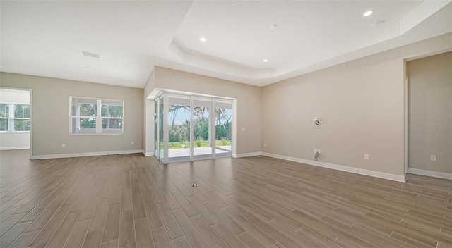 spare room with a raised ceiling and hardwood / wood-style flooring