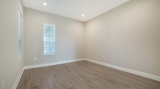 unfurnished room featuring dark hardwood / wood-style flooring and plenty of natural light