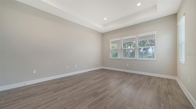 unfurnished room featuring hardwood / wood-style floors and a raised ceiling