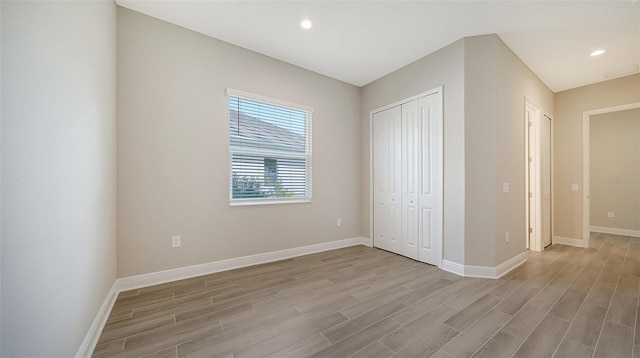 unfurnished bedroom featuring light hardwood / wood-style floors and a closet