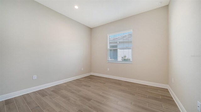 unfurnished room with light hardwood / wood-style flooring and vaulted ceiling