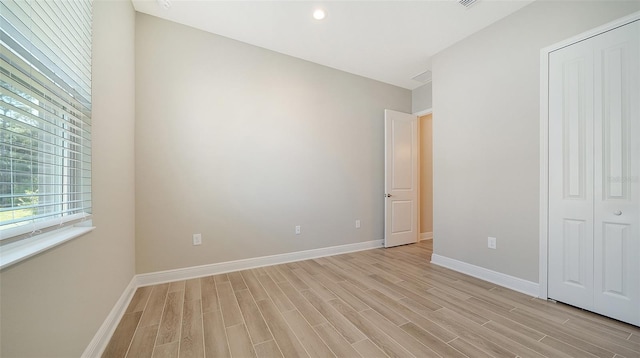 unfurnished bedroom with a closet and light wood-type flooring