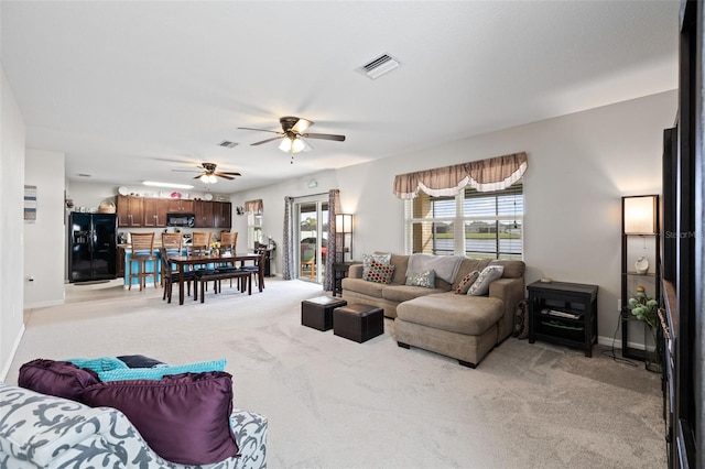 carpeted living room with ceiling fan