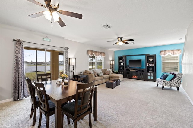 carpeted dining room with ceiling fan