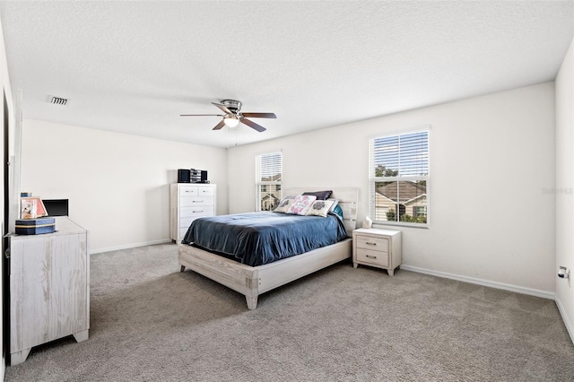 bedroom featuring ceiling fan, a textured ceiling, and carpet flooring