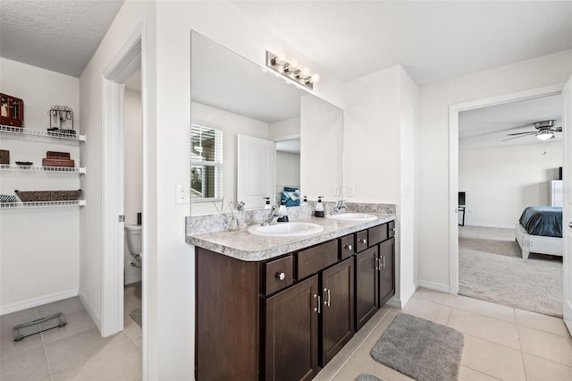 bathroom featuring a textured ceiling, tile patterned floors, vanity, and toilet