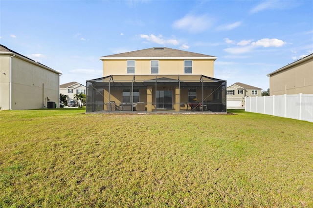 back of property with a lanai, a yard, and central AC