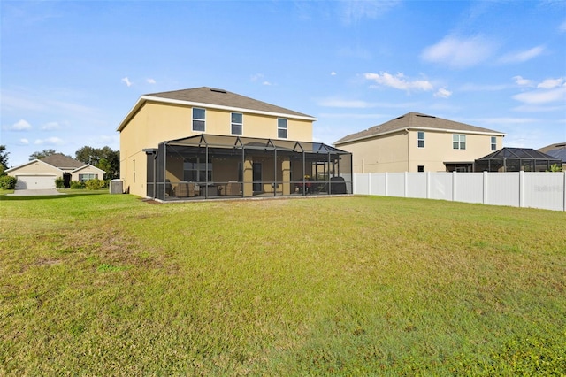 back of property featuring central air condition unit, a lawn, and a lanai