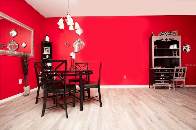 dining space featuring hardwood / wood-style flooring and a notable chandelier