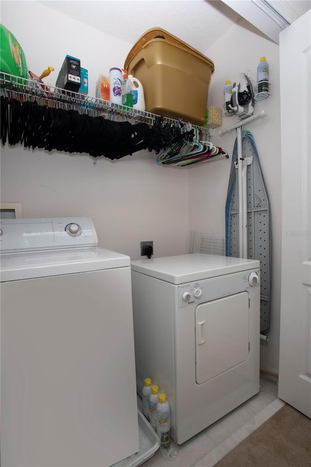 washroom featuring washing machine and clothes dryer and light tile patterned floors