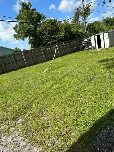 view of yard with an outbuilding and a fenced backyard