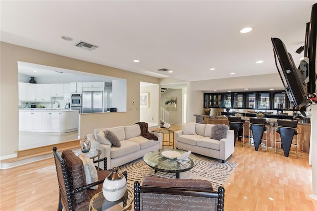 living room featuring sink and light wood-type flooring