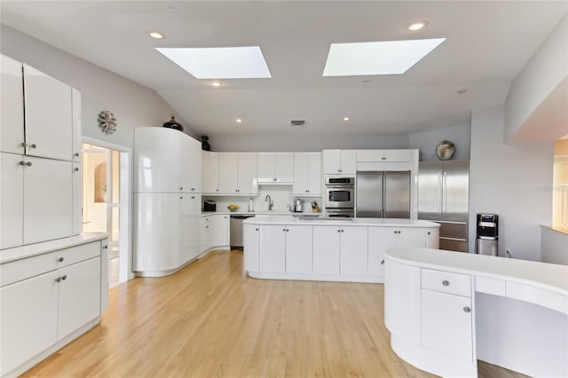 kitchen featuring stainless steel appliances, white cabinetry, and a kitchen island