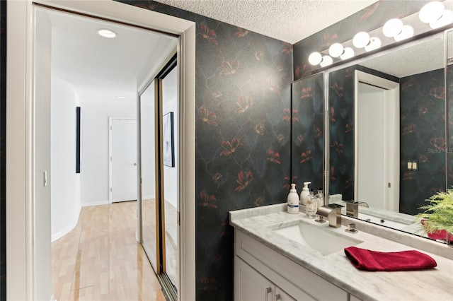 bathroom with vanity, wood-type flooring, and a textured ceiling