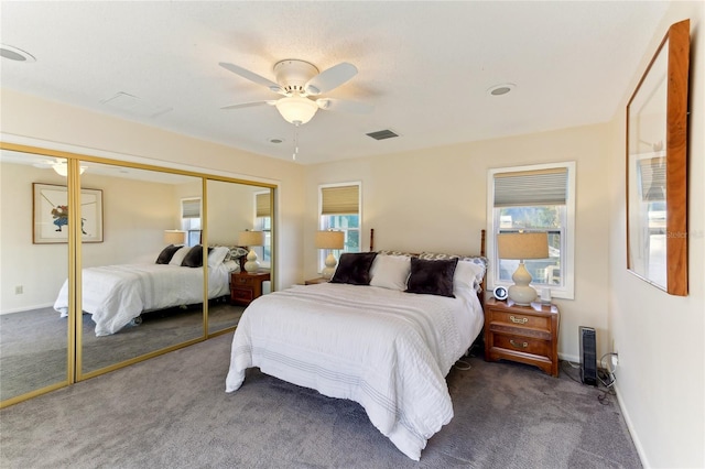 bedroom featuring dark carpet, ceiling fan, and a closet