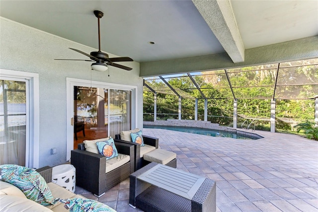 view of patio / terrace with an outdoor living space, ceiling fan, and glass enclosure