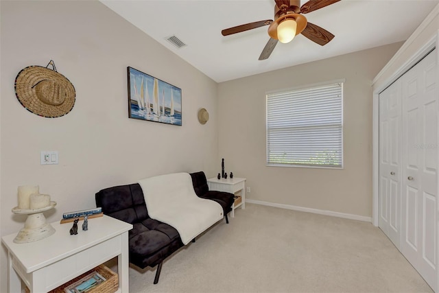 living area featuring light carpet and ceiling fan