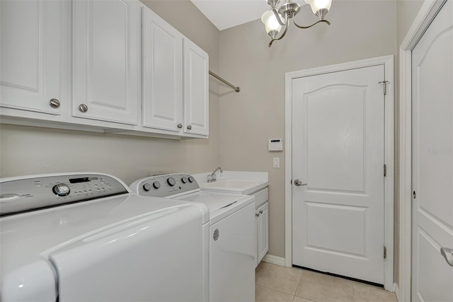 clothes washing area with light tile floors, cabinets, sink, washer and dryer, and an inviting chandelier