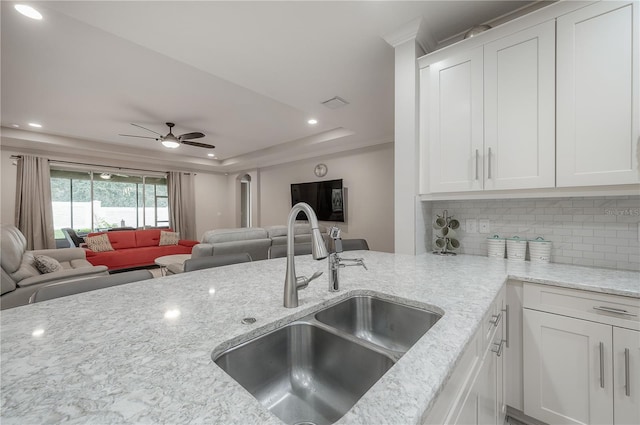 kitchen featuring white cabinetry, tasteful backsplash, sink, and light stone counters