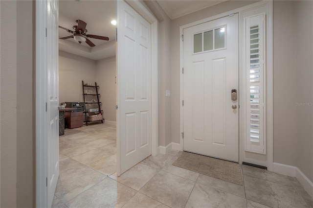 tiled foyer featuring crown molding and ceiling fan