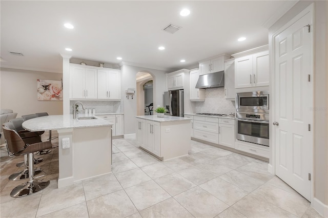 kitchen featuring stainless steel appliances, white cabinetry, a kitchen island with sink, and sink