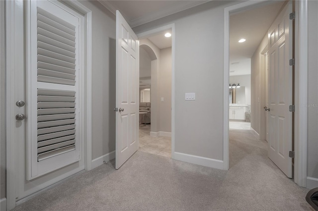 hall featuring light carpet and crown molding