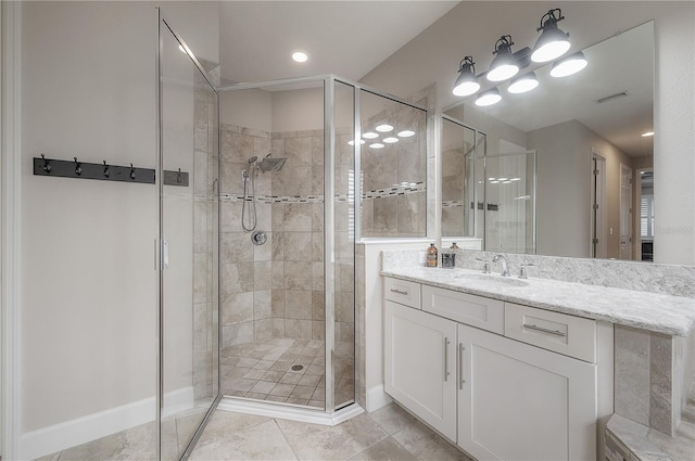 bathroom with tile patterned floors, vanity, and a shower with door