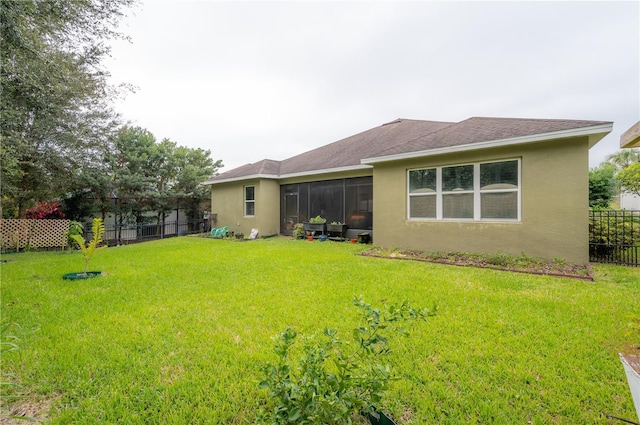 back of property featuring a sunroom and a lawn