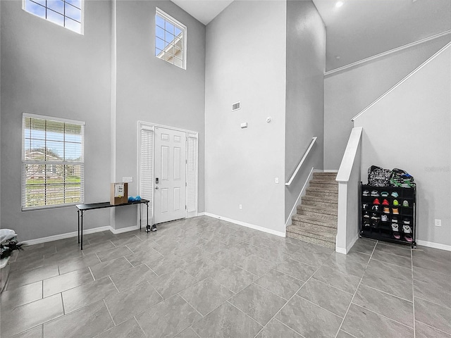 entryway featuring a wealth of natural light, visible vents, baseboards, and stairs