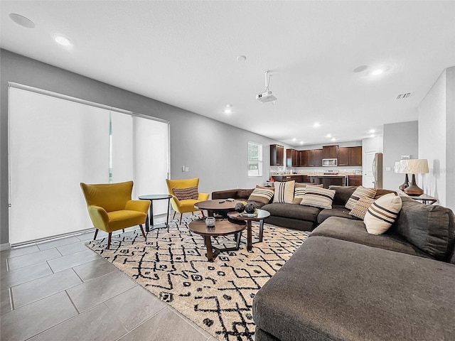 living room with light tile patterned floors, visible vents, and recessed lighting