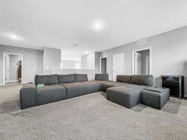 carpeted living room featuring baseboards, visible vents, and recessed lighting