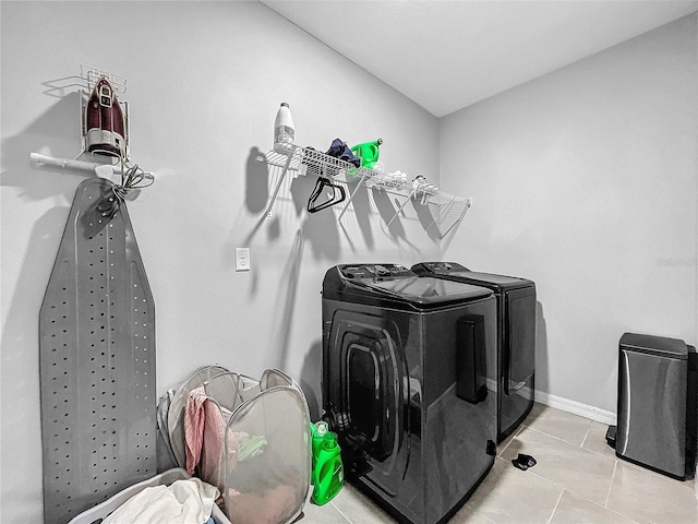 clothes washing area with laundry area, light tile patterned floors, baseboards, and independent washer and dryer