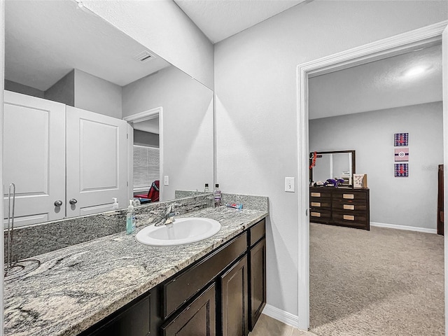 bathroom featuring baseboards, visible vents, and vanity